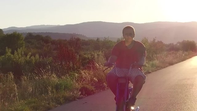 Ride moped at sunset road