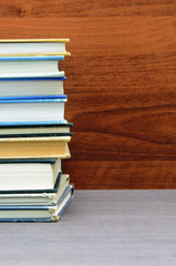 many books stacked close up photo with wood background