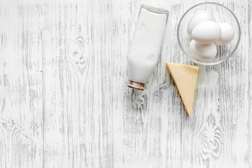 Farm products. Milk, cheese, eggs on light wooden background top view copyspace