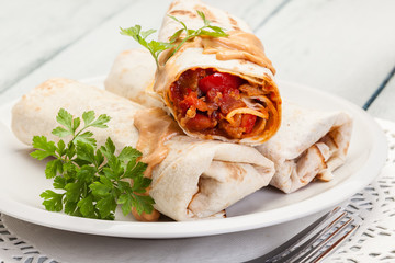 Mexican burritos wraps with mincemeat, beans and vegetables