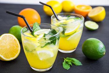 Fresh citrus cold lemonade with limes, lemons in glasses