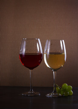 glasses with red and white wine on table, low key dark image