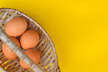 Egg collection in basket wicker isolated on yellow and black background.