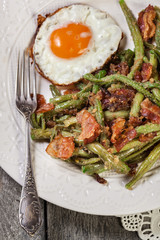 Healthy sauteed green beans with bacon and fried egg