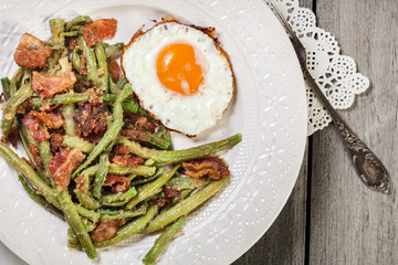 Healthy sauteed green beans with bacon and fried egg