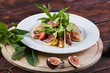Salad of bacon and figs on a wooden background