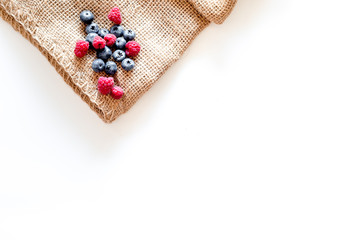 Paspberry and blueberry for preparing jam on white and canvas background top view copyspace