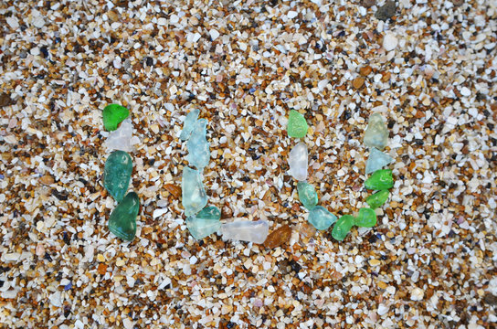 symbol ILU of glass pebbles on the sand