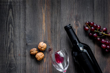 Serve wine. Bottle, glass, nuts and grape on wooden table background top view copyspace