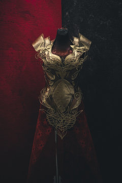 Metal Golden armor for women. Carries pieces of gold and fabrics and feathers in red color