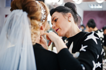 Gorgeous bride having her hair and makeup done in the beauty salon.