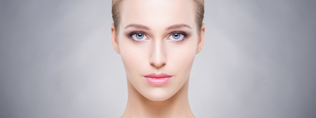 Fototapeta premium Beauty close-up portrait of beautiful, fresh and healthy girl over grey background. Make-up and skincare concept.
