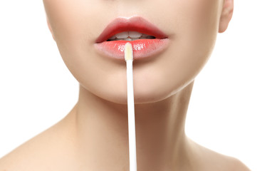 Fototapeta premium Young woman applying lip gloss, closeup