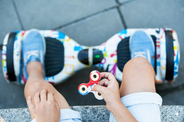 A little boy plays with spinners. She holds the spinners in her hands.