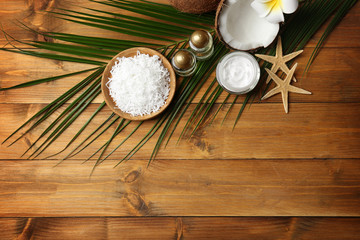 Fototapeta na wymiar Spa composition with body care products and coconut on wooden background