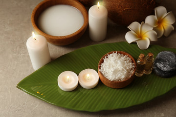 Fototapeta na wymiar Beautiful spa composition with coconut body care products and candles on table