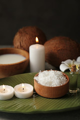 Beautiful spa composition with coconut body care products and candles on table