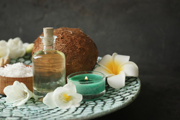 Fototapeta na wymiar Beautiful spa composition with oil in bottle and coconut on platter