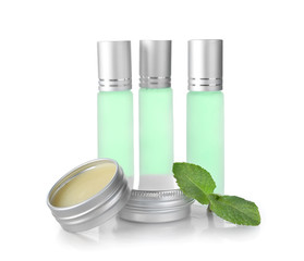 Bottles, containers with perfume and leaves of mint on white background