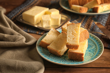 Plate with delicious sliced butter cake on wooden table