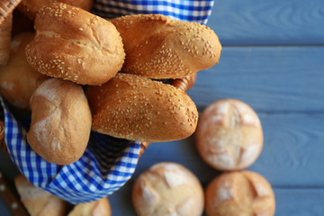 Basket with delicious bread on wooden background