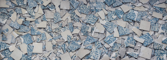 Texture from broken tiles. Background from fragments of old broken retro floor. Concept for renovation and modernization of floors and tiling.