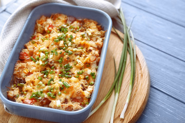 Baking tray with delicious turkey casserole on wooden table
