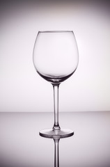 One empty wine glass on gray background