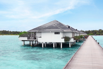 Fototapeta na wymiar View of modern beach houses on piles at tropical resort