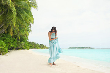 Beautiful young woman on sea beach at tropical resort