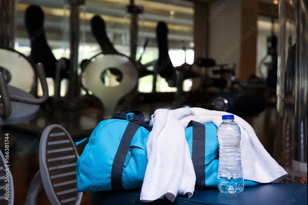 Wall mural Bag with personal things, towel and bottle of water in gym