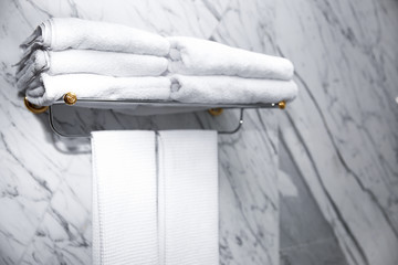 Stack of clean towels on shelf in bathroom