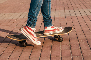 Skateboarder legs riding skateboard at street