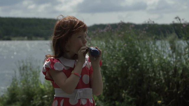 Little girl inflating balloon