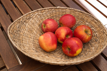 Red juicy apples on a wood table.