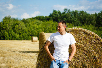 Naklejka na ściany i meble Man, male in the rural wheat agriculture field. Countryside nature landscape. Farmer in the farm. Harvest crop.