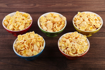 Cornflakes in bowls on wooden table
