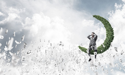 Fototapeta premium Young man on moon in sky dont want to hear anything