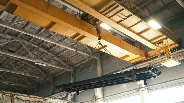 Overhead crane moves concrete slab in large at the old plant. Manufacture of reinforced concrete structures. 