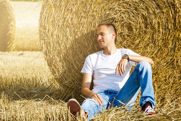 Naklejka na ściany i meble Relaxing in nature. Young man is resting in the field