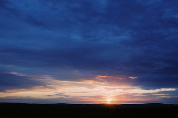 Fototapeta na wymiar Beautiful sky and field in shadow on sunset