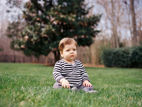 Cute boy toddler sitting on grass