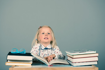 Cute little girl reading books. Educational concept.