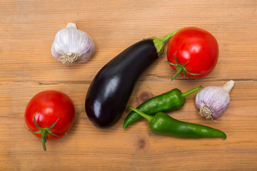 Vegetables on vintage wood background - summer harvest, soup ingredients. Rural still life from above. Tomato, eggplant, garlic, pepper