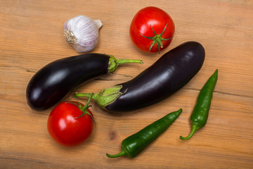 Vegetables on vintage wood background - summer harvest, soup ingredients. Rural still life from above. Tomato, eggplant, garlic, pepper