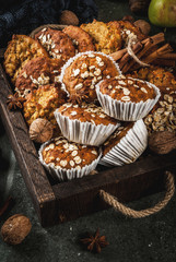 Autumn winter pastries. Vegan food. Healthy homemade baking cookies, muffins with nuts, apples, oat flakes. Cozy home atmosphere, warm blanket, ingredients for baking. Dark stone table. Copy space