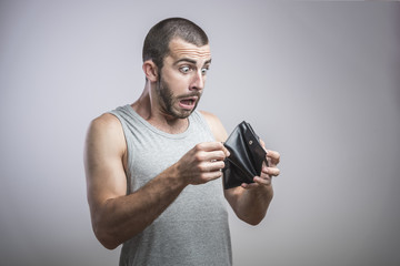 A close-up portrait of a shocked, surprised speechless man, holding an empty wallet