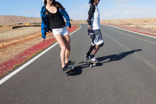 Friends Having Fun Riding a Longboard in the Desert