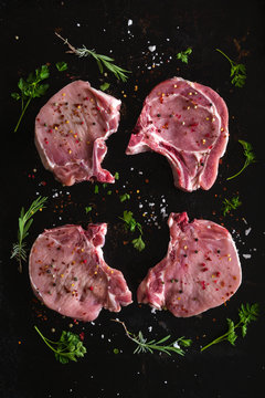 Four seasoned raw pork steaks