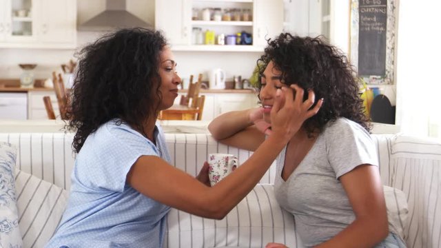 Mother Talking With Unhappy Teenage Daughter On Sofa 